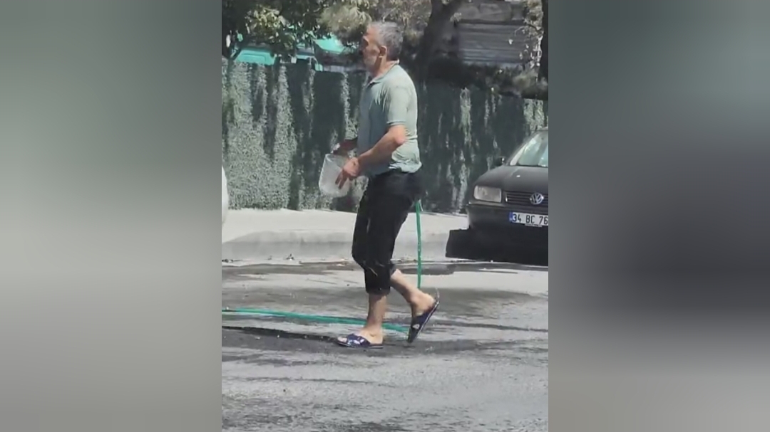 Sultangazi’de sıcaktan bunaldı: Hortumla hem kendini hem de aracını yıkadı